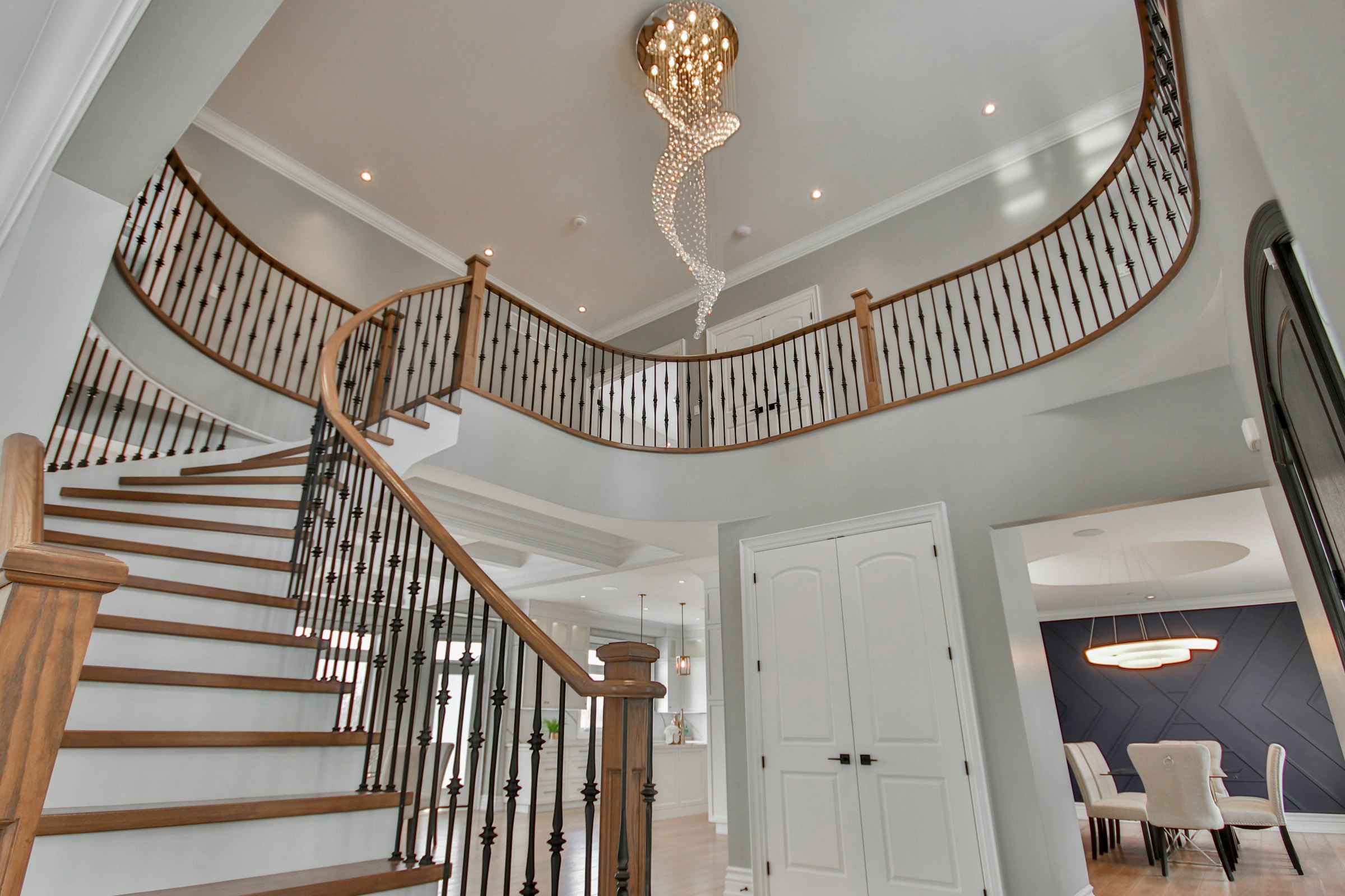 Curved staircase beneath a hanging chandelier