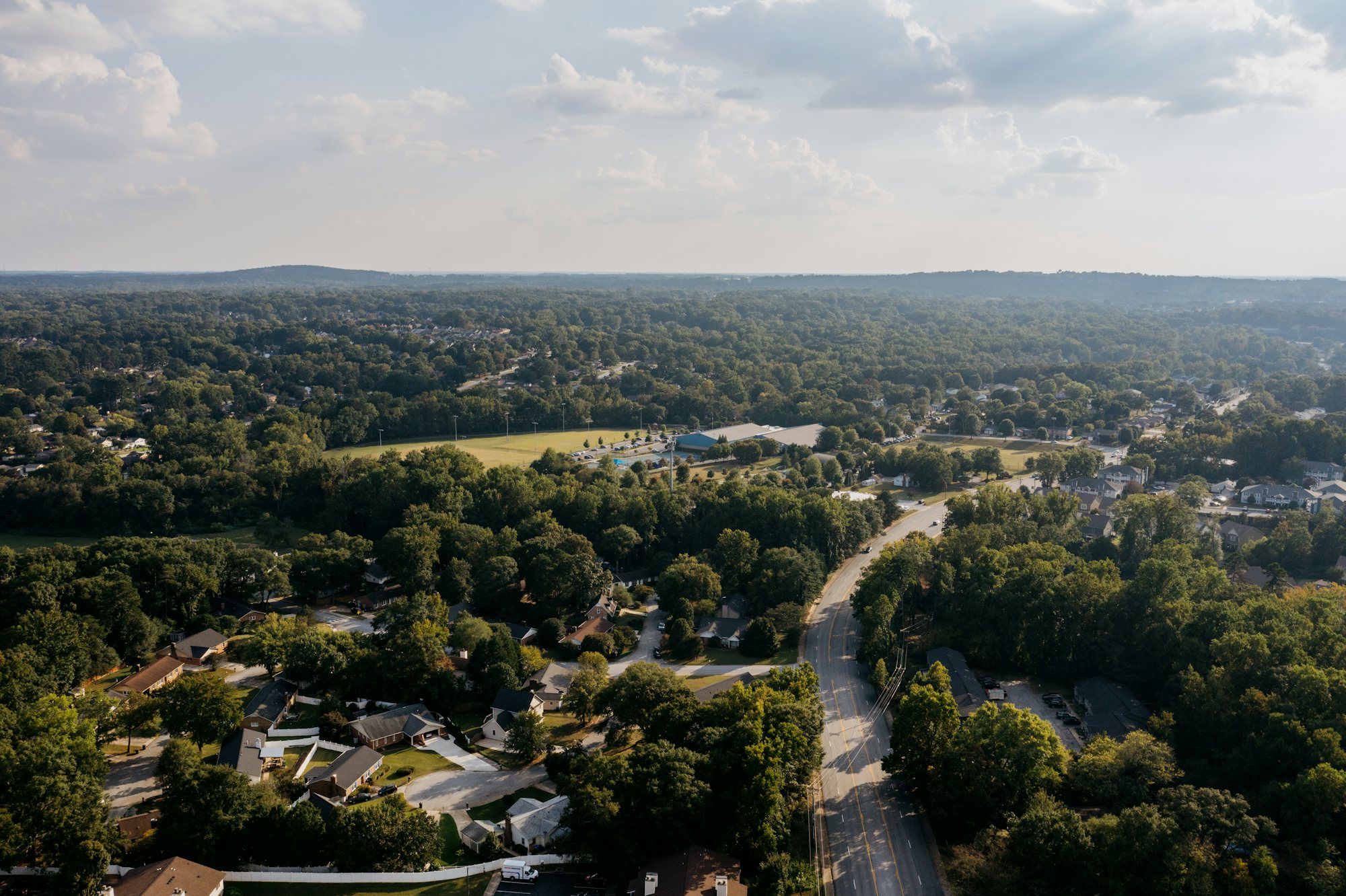 Hazy aerial view of a suburban neighbourhood surrounded by trees